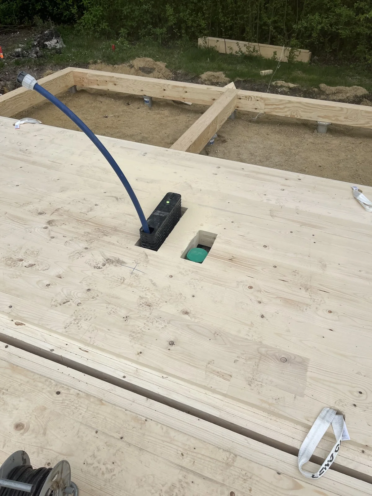Baustellenaufnahme mit punktuellen Auflagern, Holzträgern und teilweise montierten Holzbodenelementen